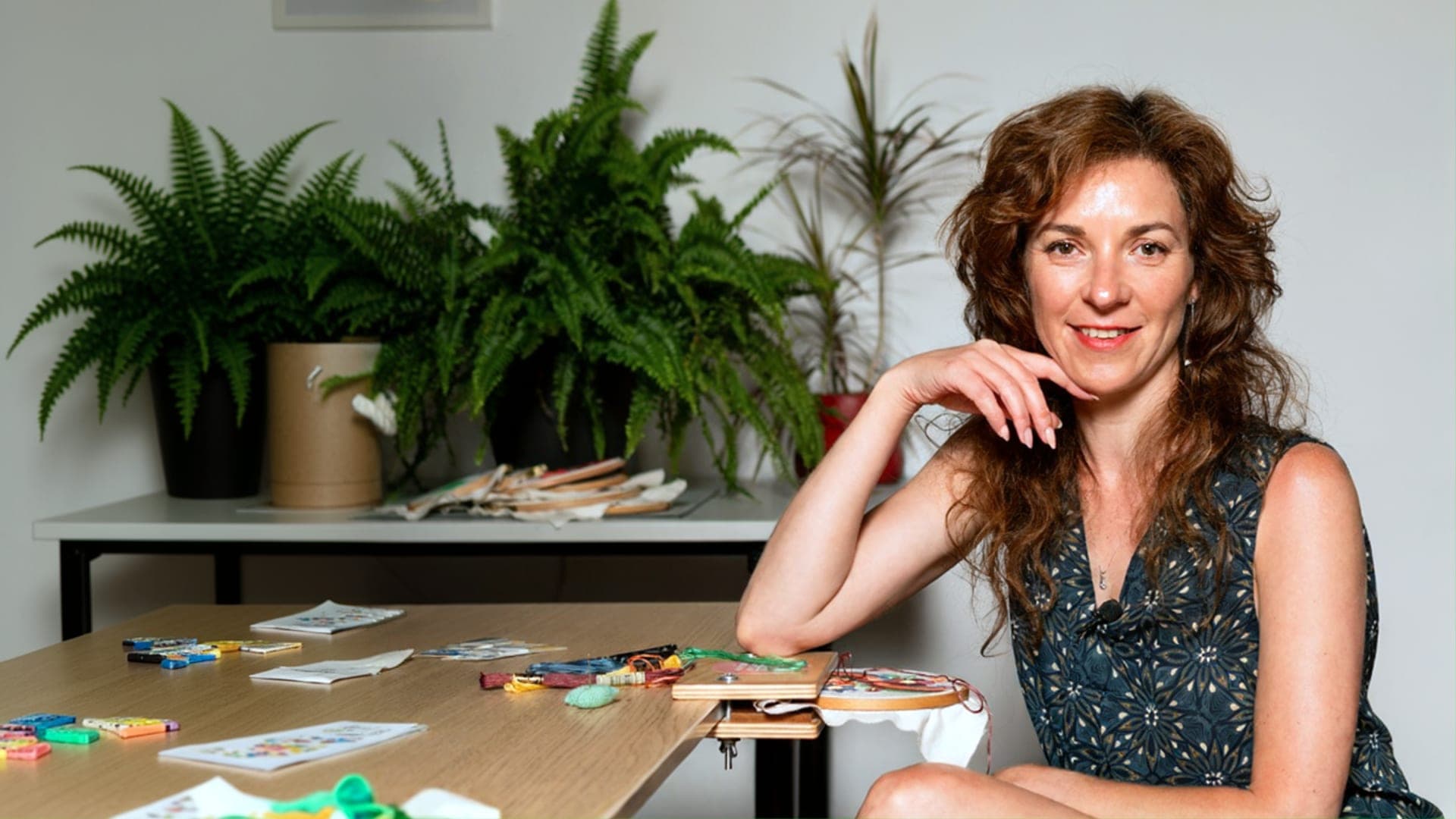 Stella working on embroidery in her bright studio